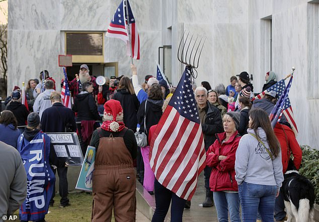 About 300 anti-lockdown protesters gathered outside the Oregon State Capitol building and forced their way in on Monday as lawmakers convened for a special session shouting 'We just want our rights back!' and 'USA!' One protester carried a pitchfork with an American flag draped on it