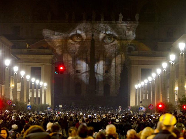 People gather to watch images projected on the facade of St. Peter's Basilica, at the Vatican, Tuesday, Dec. 8, 2015. The Vatican is lending itself to environmentalism with a special public art installation timed to coincide with the final stretch of climate negotiations in Paris. On Tuesday night, the facade ??