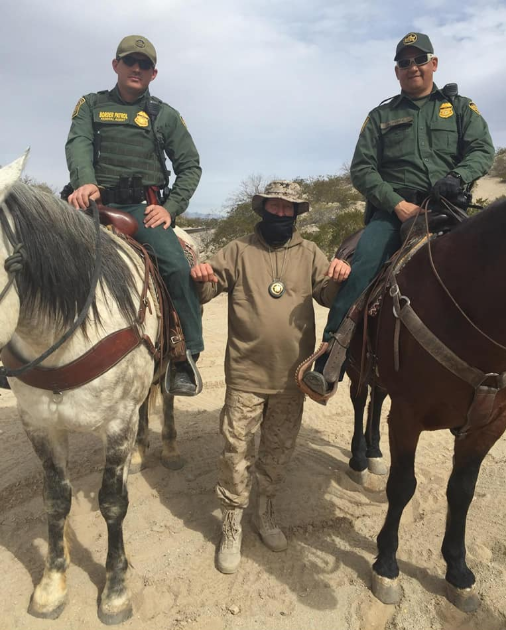 A member of the United Constitutional Patriots poses with two Border Patrol agents.